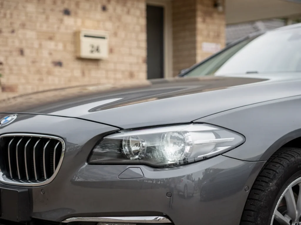 Freshly detailed graphite BMW saloon with mirror-gloss paint and restored headlights in O'Connor.