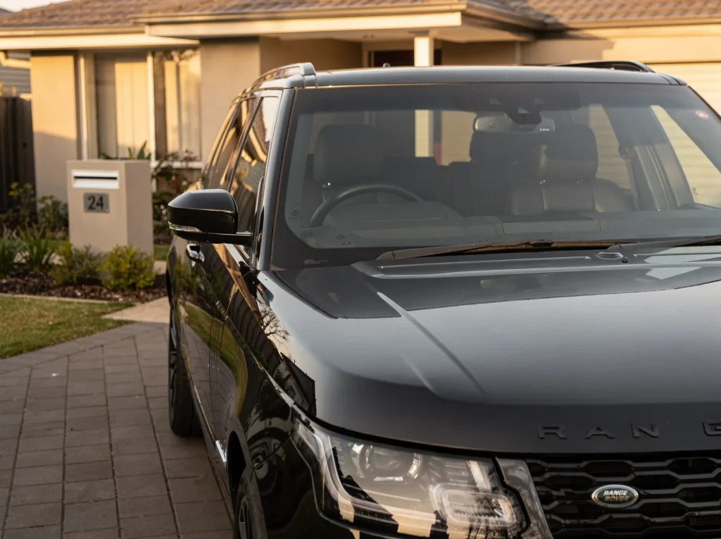 Freshly detailed gloss black Range Rover SUV on a driveway in O'Connor at golden hour.